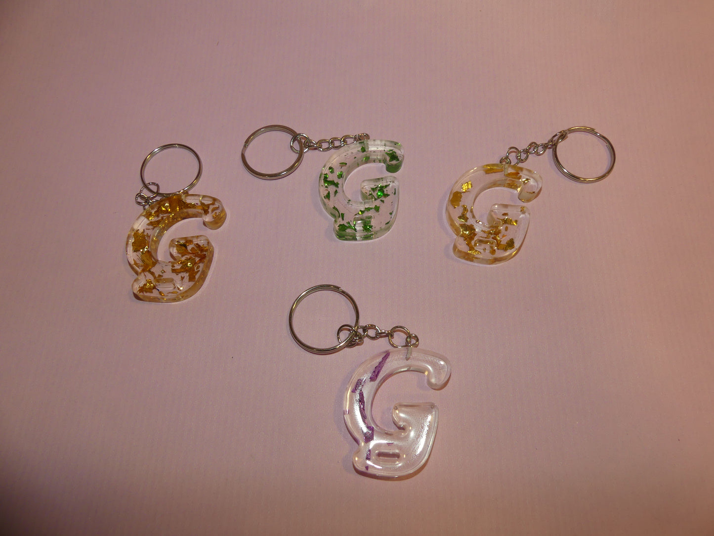 Porte-clefs Alphabet G transparent/feuilles d'or vertes